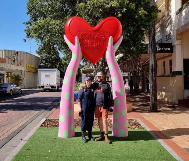 Holly Ahern and Eden Crawford stand in front of their artwork "In The Heart"